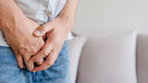 Mężczyzna trzymający się za krocze